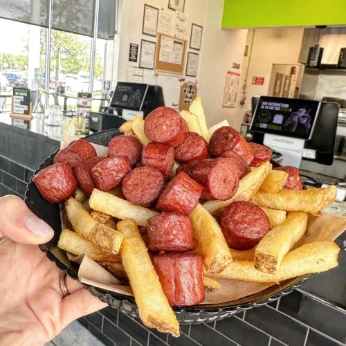 Salchipapas, salchichas fritas con papas fritas en los verdes